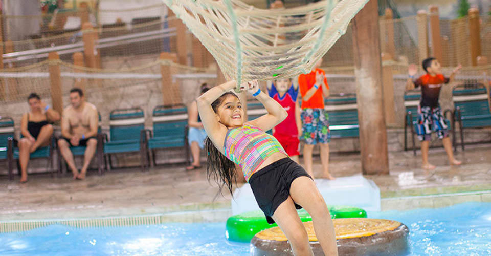 Girl making her way across from Frog Bog Log course at the Great Wolf Lodge Indoor Water Park in Wisconsin Dells 960